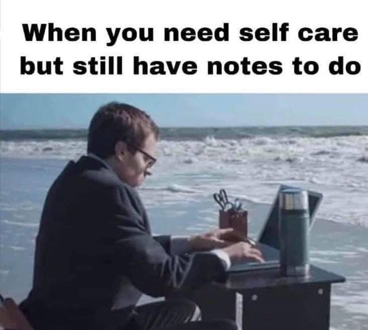 a man sitting at a table on top of a laptop computer next to the ocean