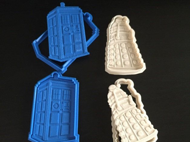 three cookie molds shaped like tardishes on a black table with one in the shape of a doctor who's door