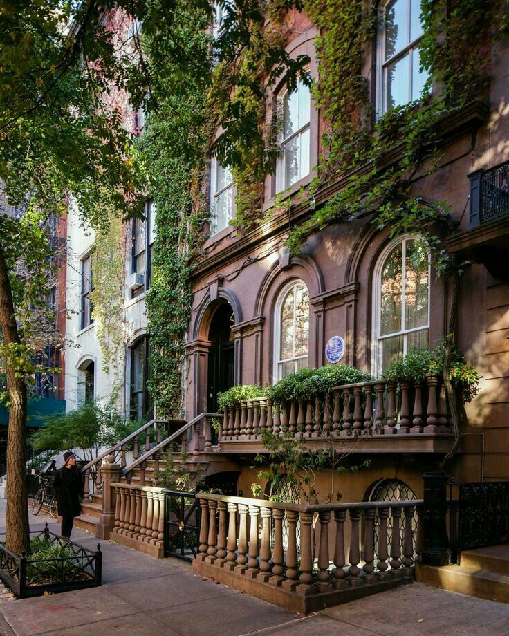 an apartment building with many windows and balconies on the side of the street