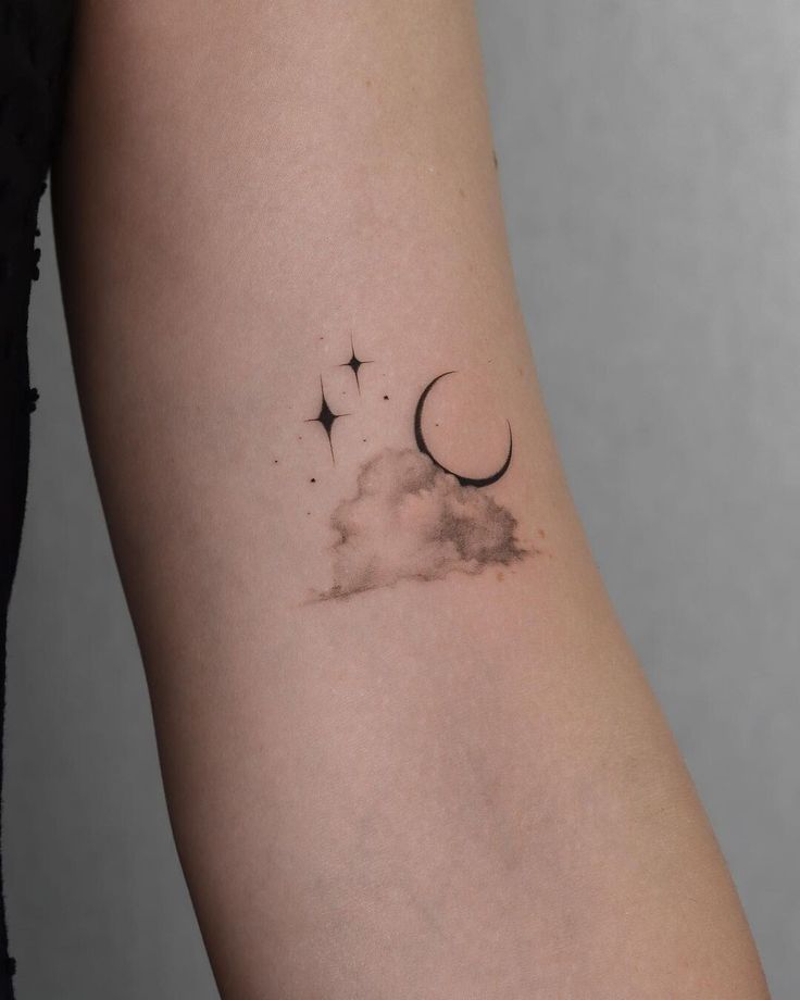 a woman's arm with a crescent and stars tattoo on it