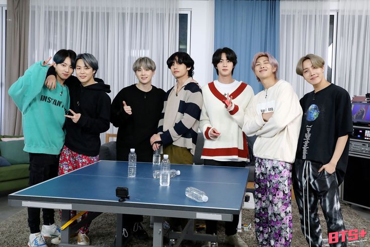 a group of young men standing next to each other in front of a ping pong table