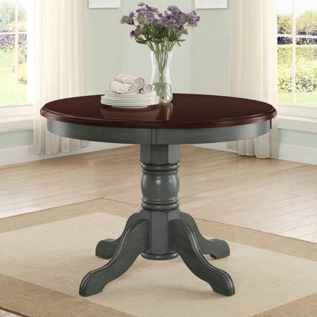 a dining room table with flowers in a vase on it's centerpiece,