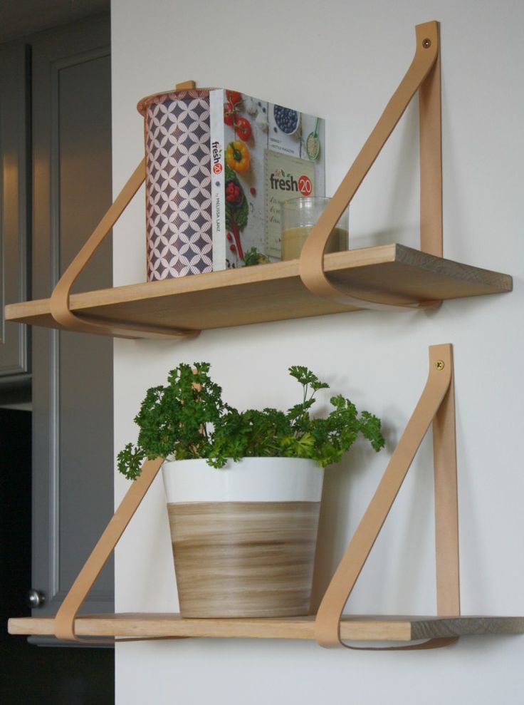 two wooden shelves with plants and books on them, one shelf has a potted plant