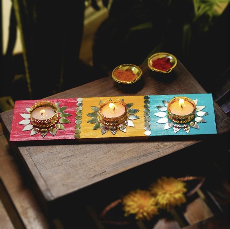 three candles sitting on top of a wooden table