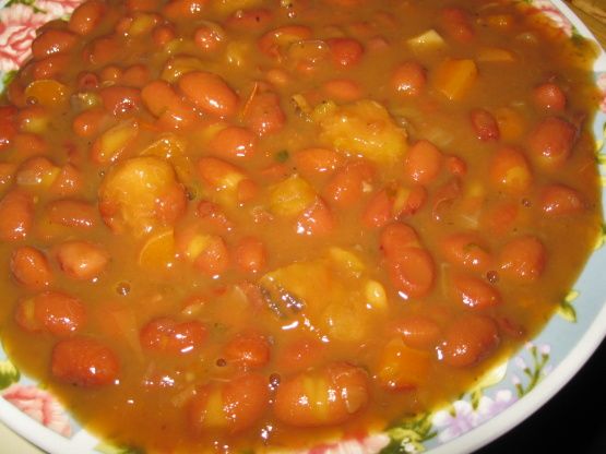 a bowl filled with beans and carrots sitting on top of a table next to a plate