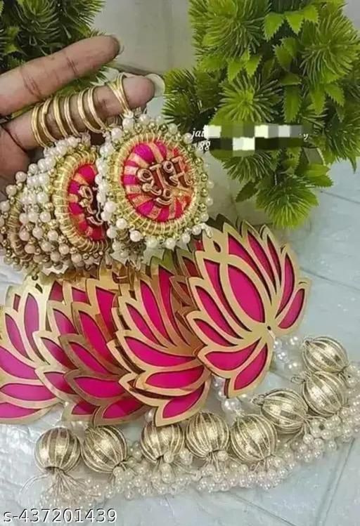 pink and gold colored bangles with matching bracelets on display in front of green plants