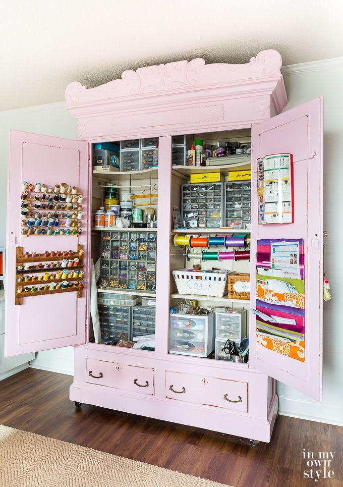 a pink cabinet filled with lots of craft supplies