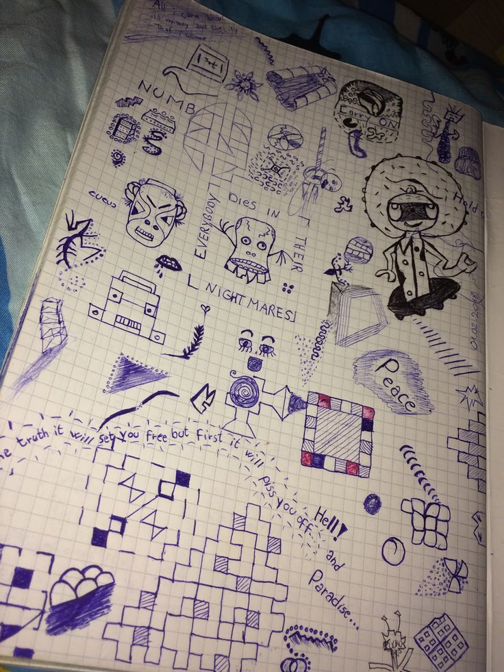 a notebook covered in doodles and drawings on top of a blue sheet with writing