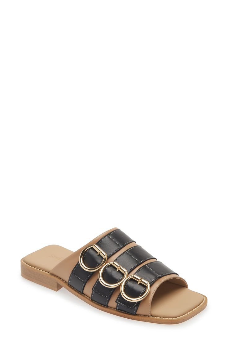 Whether you're polishing up your casual office look or dressing up for brunch, this buckled slide sandal will enhance a variety of looks. Leather upper and lining/rubber sole Made in Portugal Black Owned/Founded Modern Open Toe Mules With Buckle Closure, Black Slide Mules With Buckle Closure, Modern Sandals With Buckle Closure For Work, Modern Buckle Closure Sandals For Work, Leather Slides With Adjustable Strap, Flat Shape, Flat Mules With Buckle Closure, Elegant Mules With Buckle Closure In Slide Style, Elegant Slide Mules With Buckle Closure, Trendy Sandals With Rectangular Buckle Closure