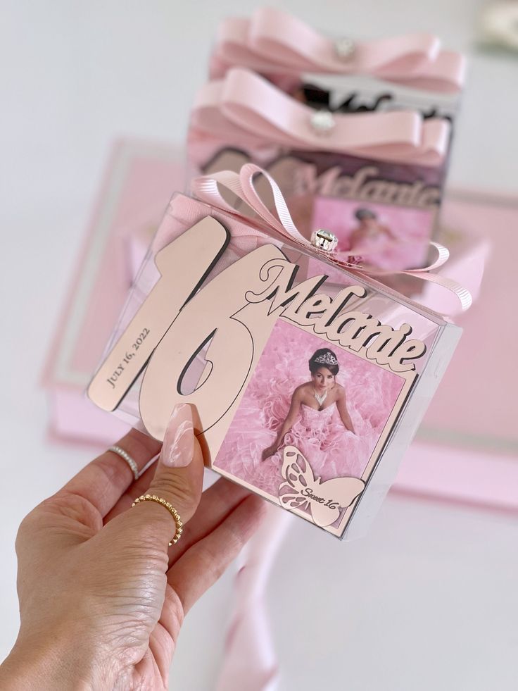 a person holding up a card that says welcome to the bride with a pink bow on it