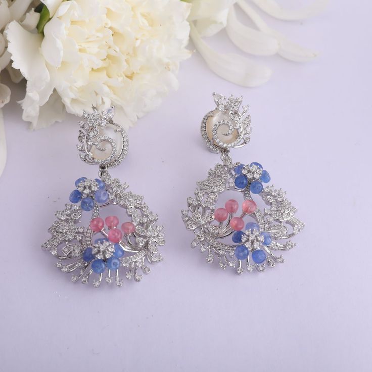 Description : This blooming statement earring is a fusion of opulent CZ stones and colorful beryl beads that showcase the mythical Indian floral motifs depicting the shape of Chaand. Handcrafted on 925 silver by our skilled artisans, these earrings have a royal and timeless look ideal for women who love nature and elegance. Product Information : Metal: 925 Silver with White Rhodium Plating Length: 6cm Stones: Semi precious stones Findings- Push Back Fusion Style Gemstone Chandelier Earrings For Wedding, Silver Gemstone Danglers For Wedding, Fusion Style Gemstone Drop Bridal Earrings, Fusion Style Gemstone Chandelier Drop Earrings, Silver Fusion Chandelier Earrings, Fusion Style Gemstone Danglers Earrings, Elegant Multicolor Cubic Zirconia Crystal Earrings, Luxury Silver Multi-stone Earrings, Luxury Multi-stone Silver Earrings