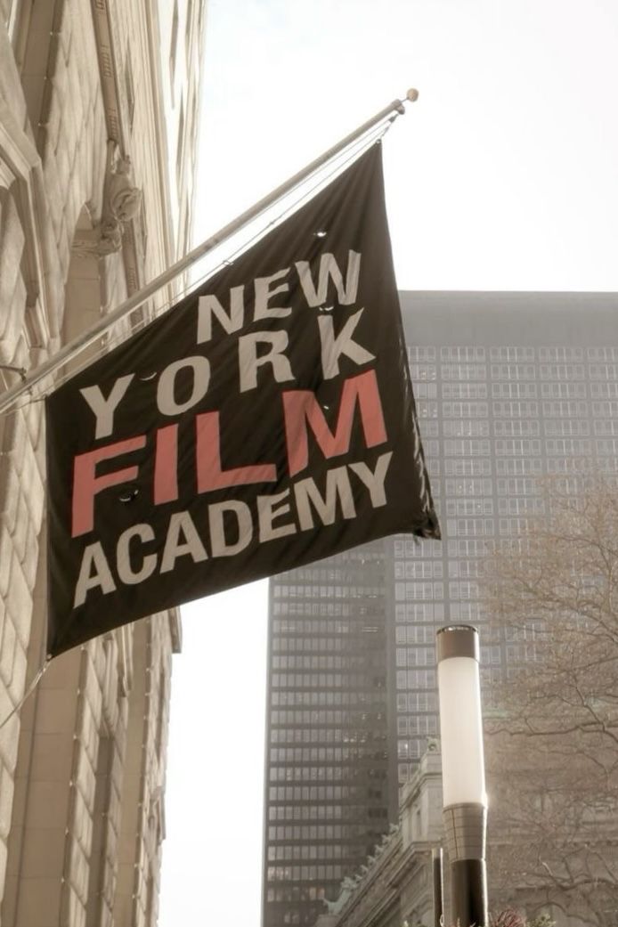 a sign that says new york film academy hanging from the side of a tall building