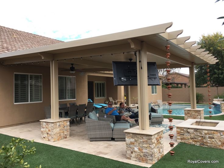 an outdoor living area with patio furniture and pool in the backgroung yard