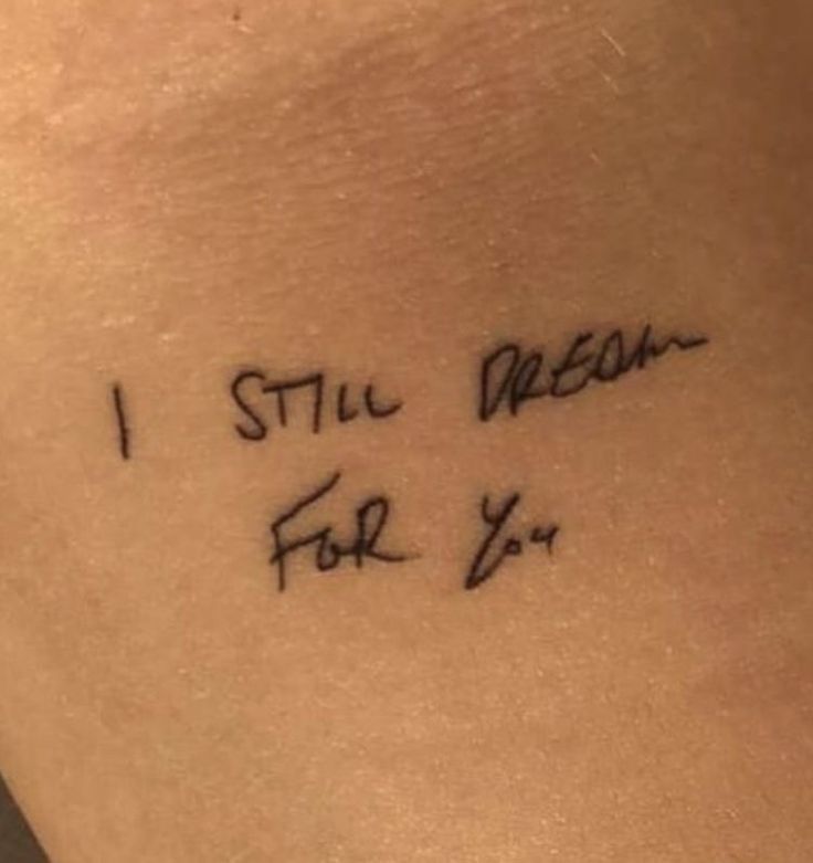 i still dream for you tattoo on the back of a woman's left arm