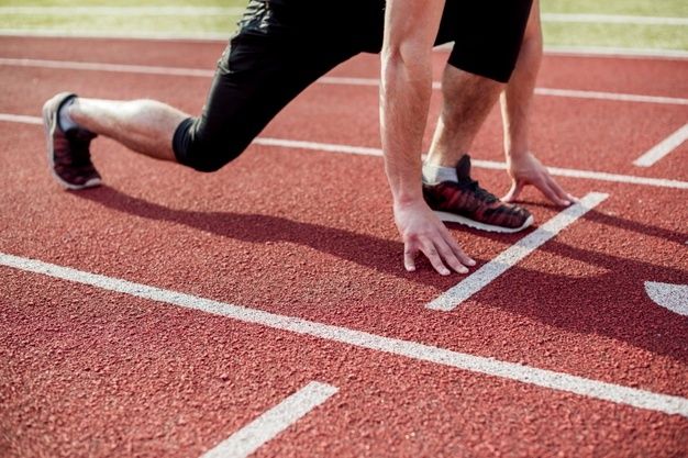 a man running on a race track with his foot in the air