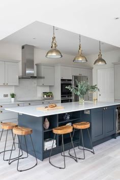 a kitchen with an island and stools in it