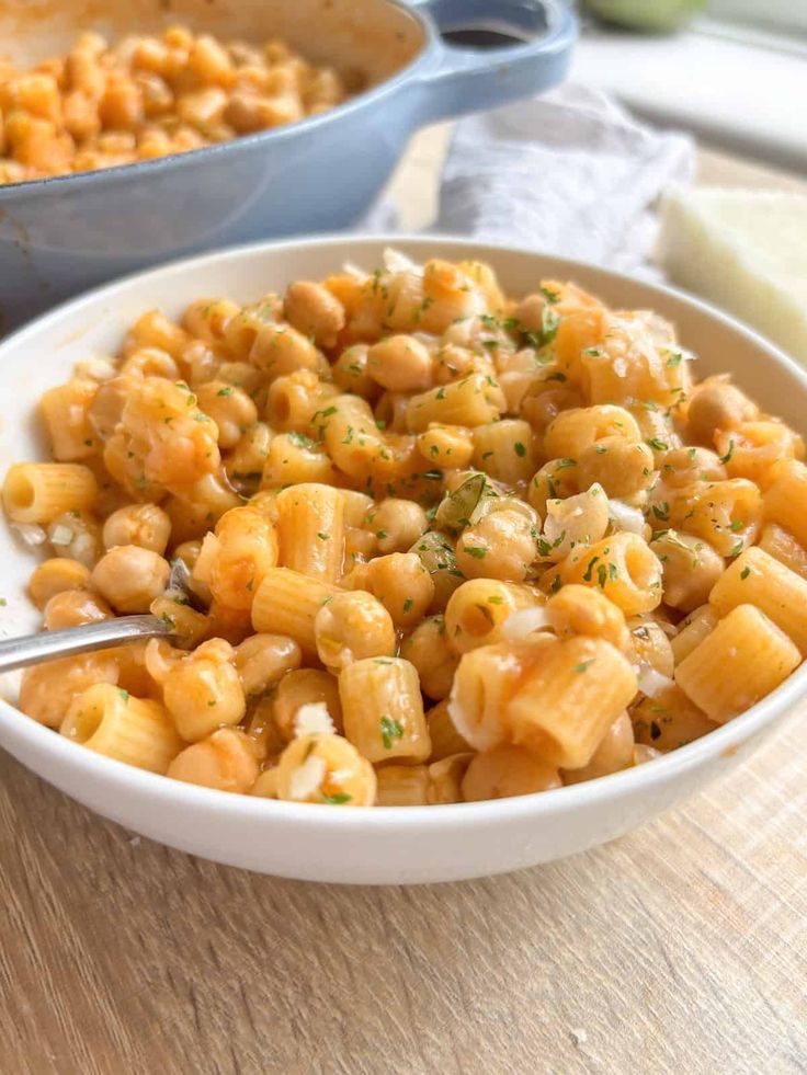 a white bowl filled with macaroni and cheese on top of a wooden table