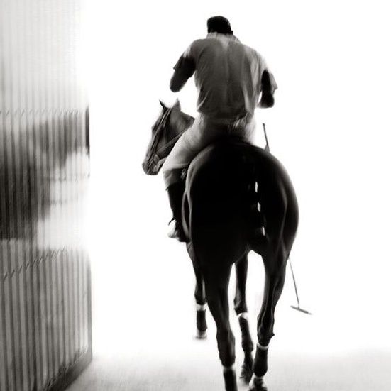 a man riding on the back of a brown horse in a tunnel between two walls