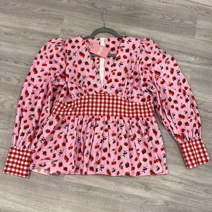 This Adorable Shirt Is From Uk Slow Fashion Brand Molby. It’s A Uk Size 18, Which Is Like Us 14. New With Tags, Zipper Up The Back, Fit And Flare Style, Puff Sleeves. The Proportions Were Off For Me (I Have A Short Waist And Am Very Tall) So I’m Bummed To Sell But I’ve Never Worn It Because Of That. Fitted Cherry Print Tops For Spring, Cute Long Sleeve Red Blouse, Cute Red Long Sleeve Blouse, Red Strawberry Print Tops For Spring, Red Strawberry Print Top For Spring, Cute Red V-neck Top, Fitted Pink Top With Strawberry Print, Long Sleeve Tops With Strawberry Print For Spring, Red Cherry Print Tops For Spring