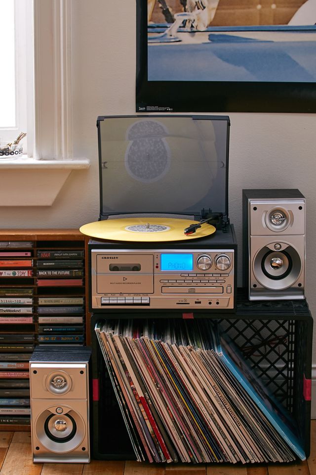 an old record player sitting on top of a shelf filled with vinyl records and cds