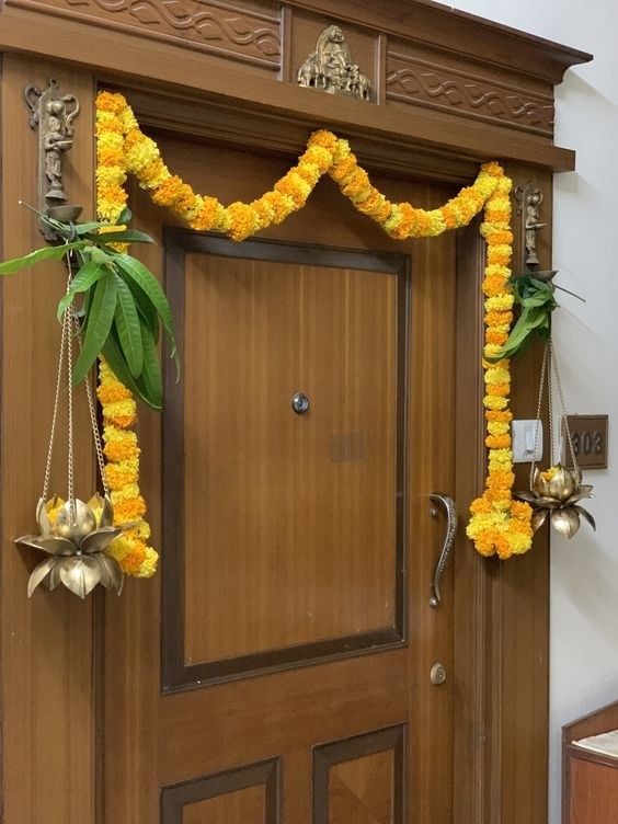 a wooden door decorated with yellow flowers and greenery hanging from it's side