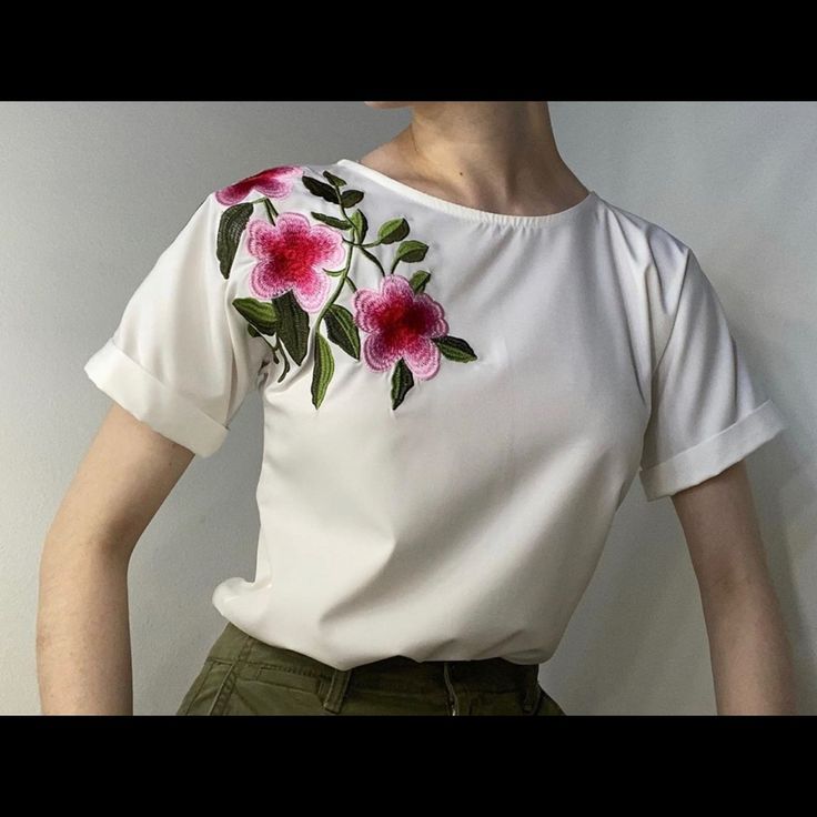 a woman wearing a white shirt with pink flowers on it