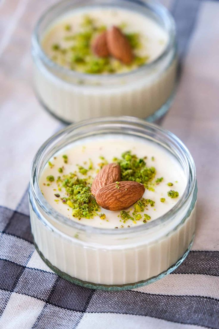 two small glass bowls filled with pudding and nuts