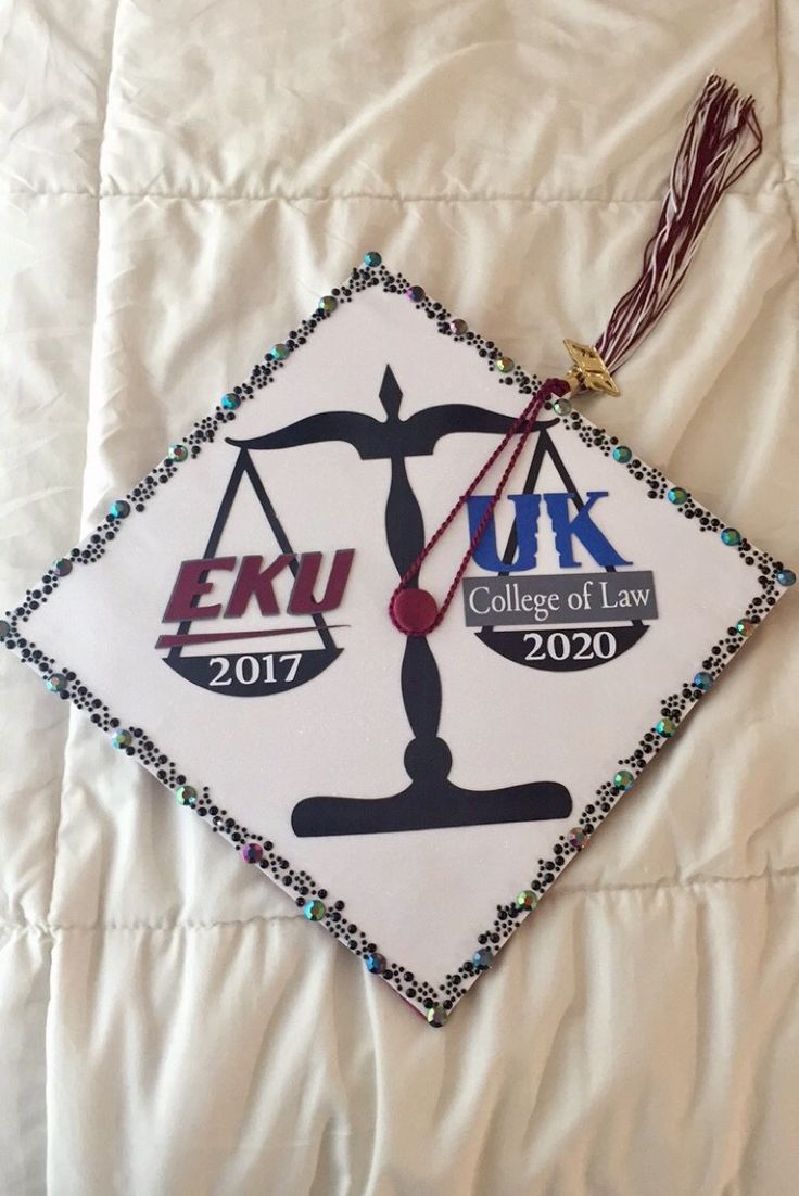 a white graduation cap with the words e k university law on it and a judge's scale