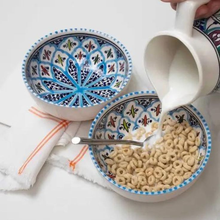 a person pouring cereal into a bowl