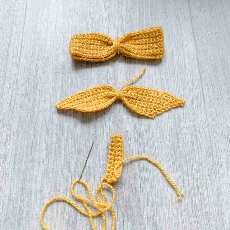 two crocheted bows are sitting on a table