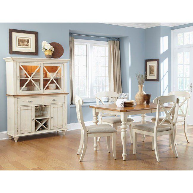 a dining room table with chairs and a china cabinet in the corner, against a blue wall