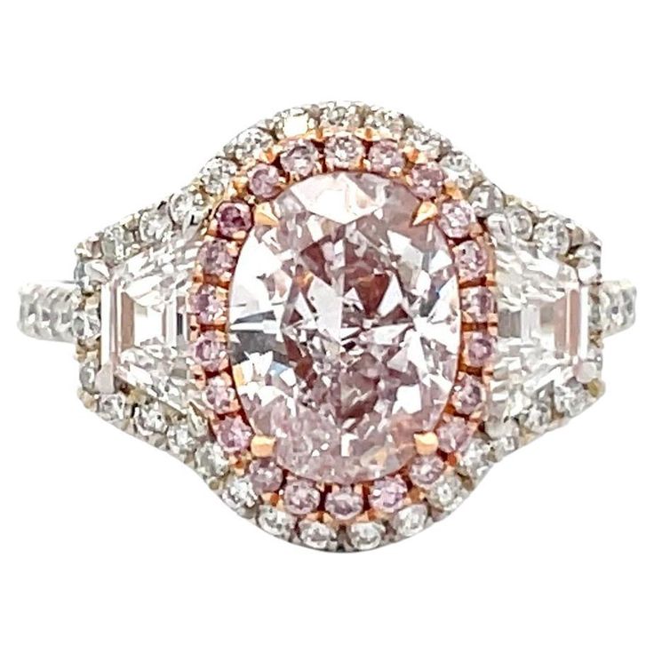 GIA Certified engagement ring featuring one Very Light Pink Oval weighing 2 Carats SI1, flanked with two Trapezoids, 0.59 Carats D VS, 22 Fancy Light Pink diamonds, 0.11 Carats VS, and 53 round brilliants weighing 0.51 carats, D-E VS, in Platinum and 18 Karat Rose Gold. Pink Diamond Halo Ring, Famous Engagement Rings, Blue Diamond Engagement Ring, Oval Halo Engagement Ring, Yellow Diamonds Engagement, Edwardian Engagement Ring, Fancy Light, Pink Diamond Ring, Pink Diamonds