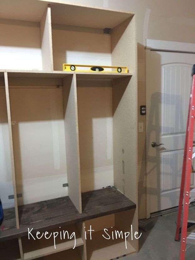 an empty room with some shelves and ladders in it, next to a door