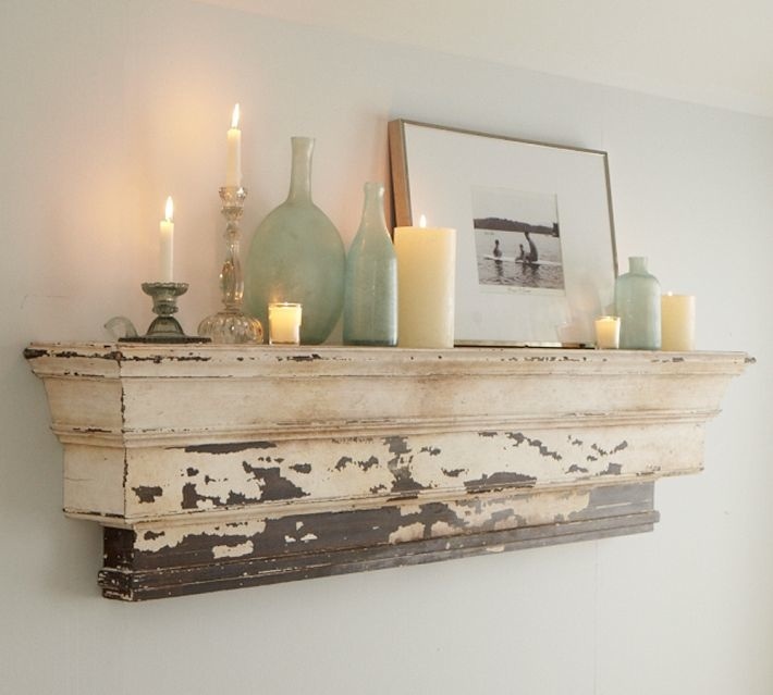 a mantle with candles and pictures on it