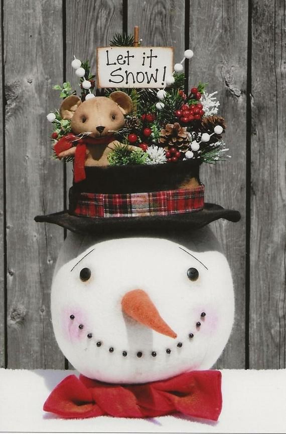 a snowman with a sign on it's head that says let it snow