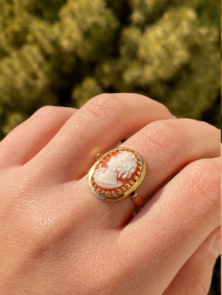 The Veena Ladies Antique Cameo Ring in 14K Yellow Gold. Crafted in 14 karat yellow gold, this ring is in excellent condition. Currently a finger size 8, this ring can be adjusted in size upon request. Each piece has been hand selected and meticulously identified and graded by a Graduate Gemologist who has been awarded a degree by the Gemological Institute of America (GIA). Please visit our Shop's About Page or our website for more information about our jewelry. Sizing for all rings is an additio Oval Gold Enamel Ring In 14k Gold, Antique 14k Gold Open Ring, 14k Gold Hallmarked Enamel Ring, Hallmarked 14k Yellow Gold Enamel Ring, 14k Yellow Gold Enamel Wedding Ring, Yellow Gold 14k Enamel Wedding Ring, Wedding 14k Yellow Gold Enamel Ring, Luxury Cameo Ring As Gift, Cameo 14k Gold Rings For Collectors