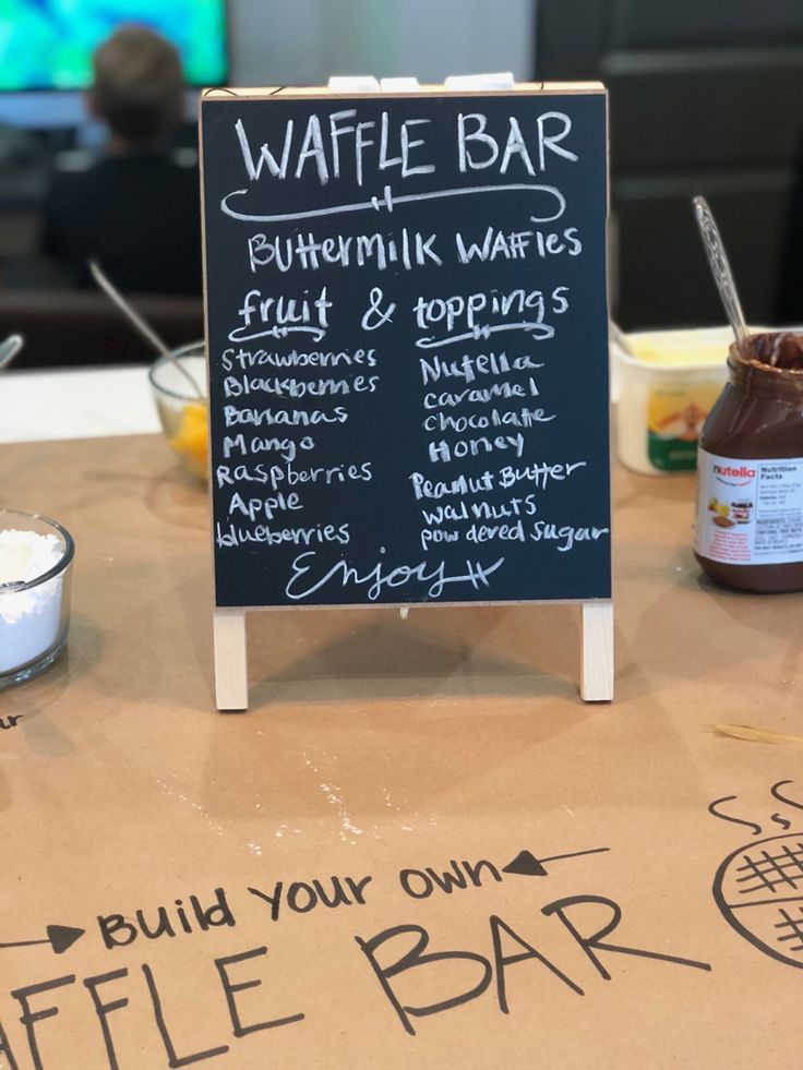 a chalkboard sign sitting on top of a table next to other food and drinks