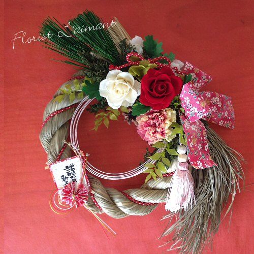 a wreath with flowers and feathers on a red background