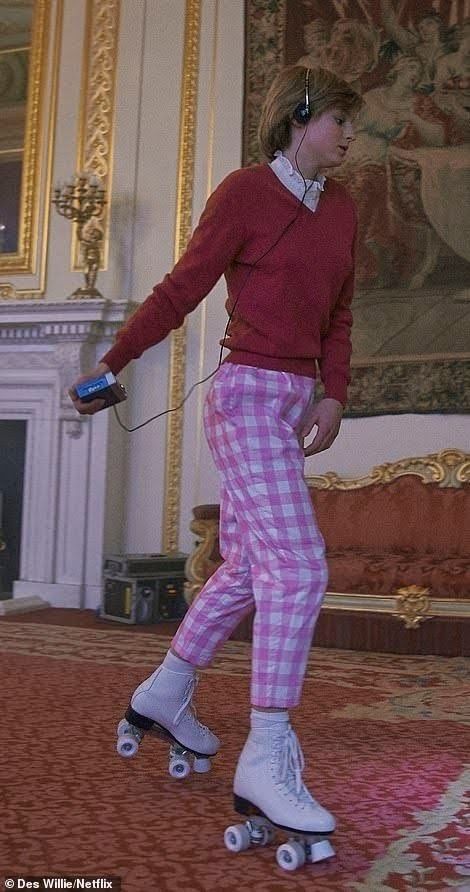 a girl in pink and white checkered pants skates through the room while listening to headphones