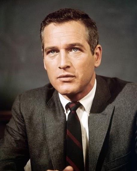 a man wearing a suit and tie sitting down