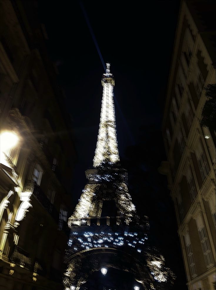 the eiffel tower lit up at night in paris, france as seen from below