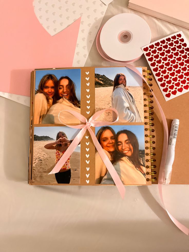 an open photo album with three photos on it next to a ribbon and scissors, along with other items