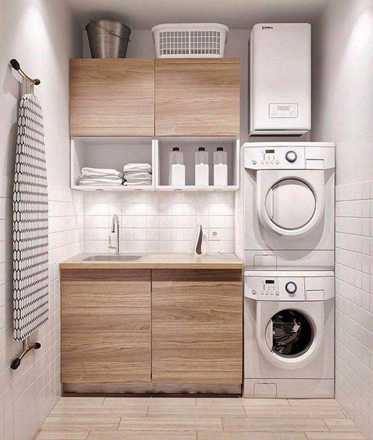 a washer, dryer and cabinets in a small room with tile flooring