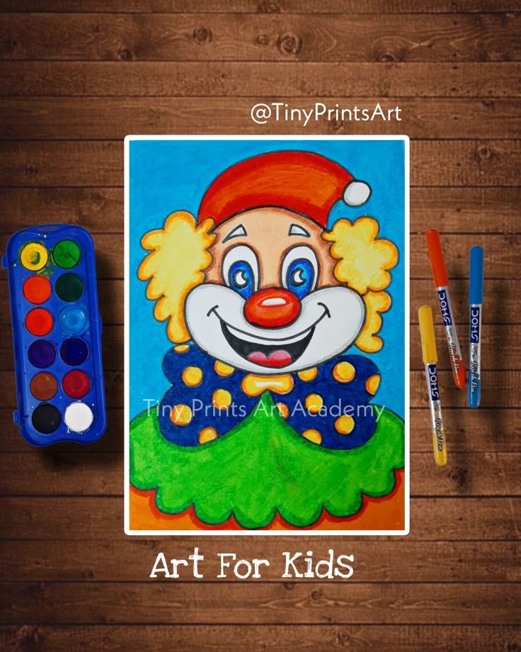 a painting of a clown with paintbrushes next to it on a wooden table