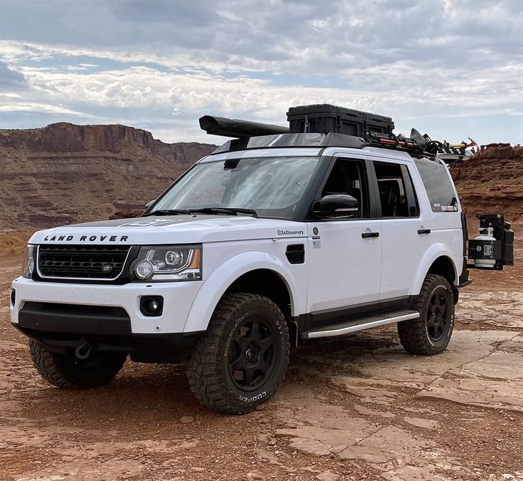 a white land rover vehicle parked in the desert