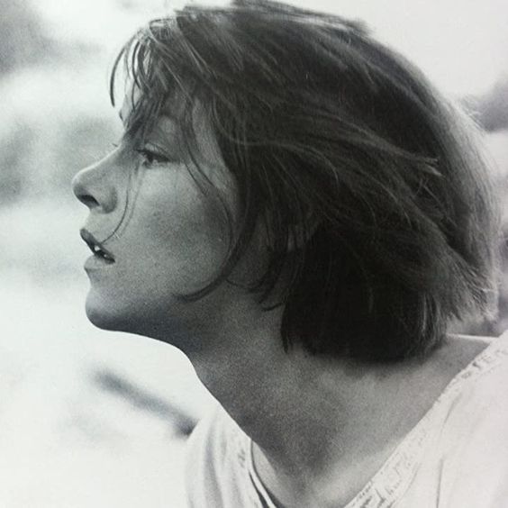 black and white photograph of a man with long hair looking off to the side in profile