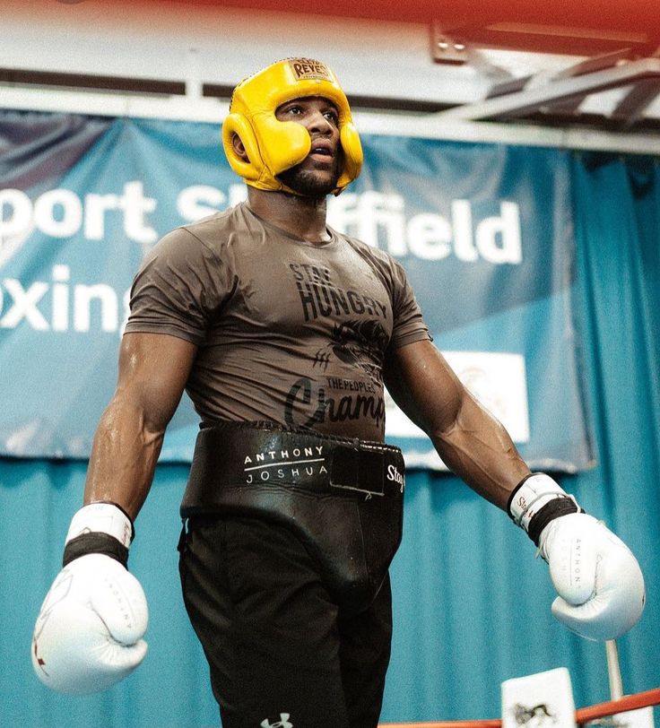 a man wearing boxing gloves and yellow headgear