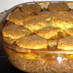 a casserole dish filled with biscuits and meats on top of a stove