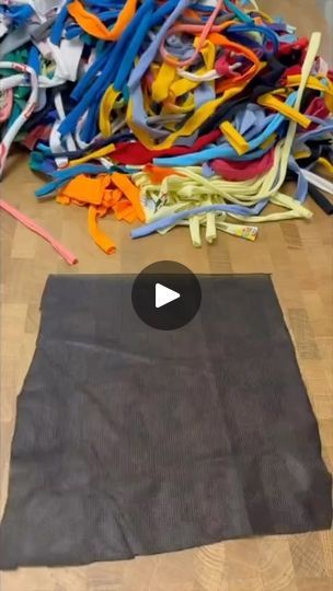 a pile of clothes sitting on top of a wooden floor next to a pile of scissors