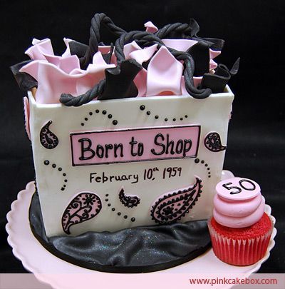 a birthday cake that is shaped like a shopping bag and has pink frosting on it